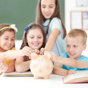 Children putting money in a piggy bank